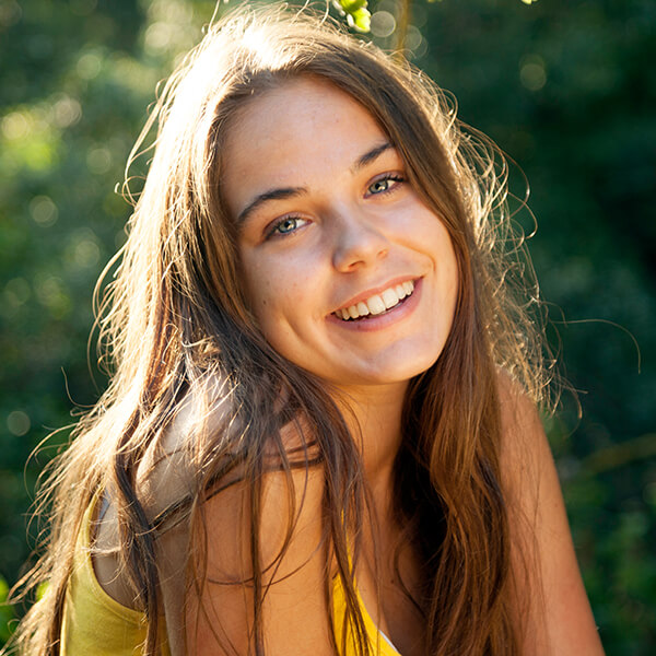 A young woman smiling outdoors