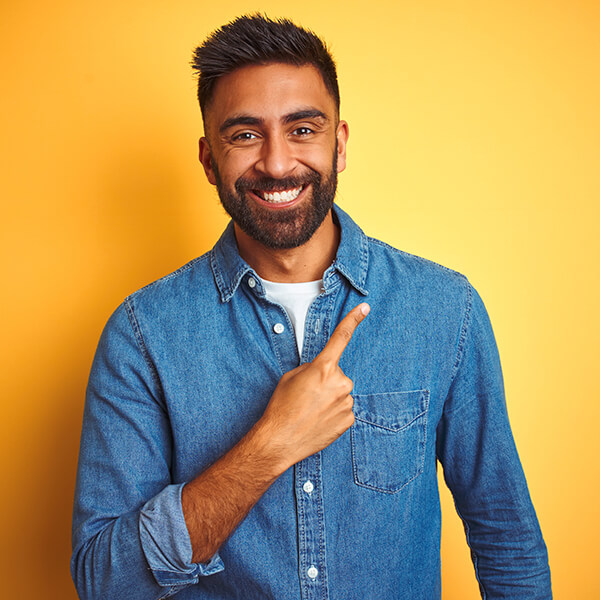 Man in a plaid shirt smiling on a yellow background